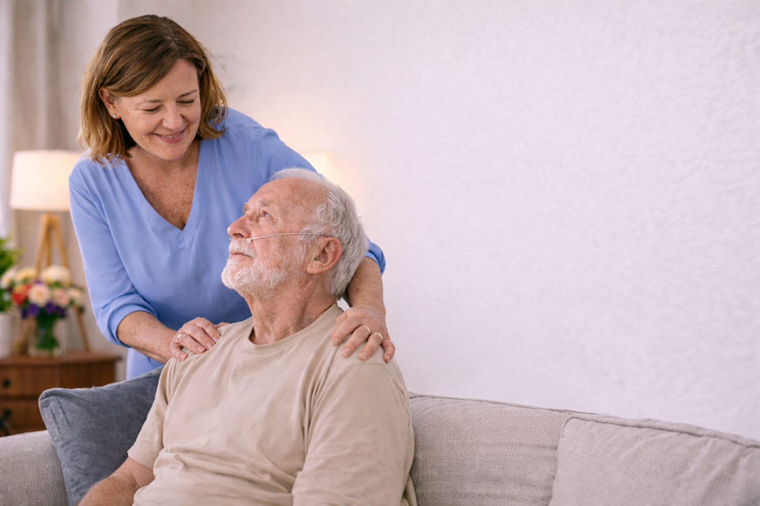 Carer assisting an elderly man at home